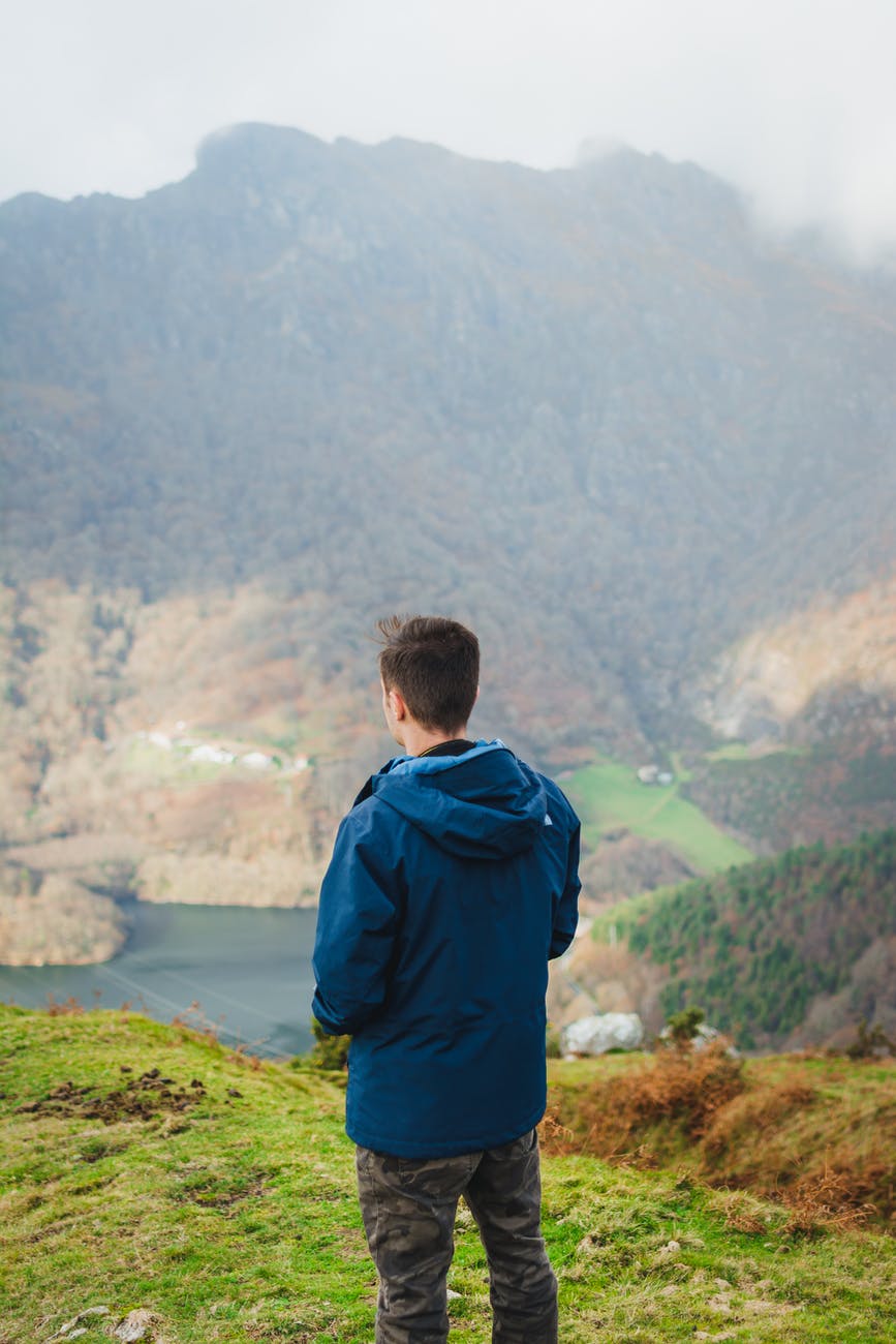 unrecognizable man admiring view in mountainous terrain