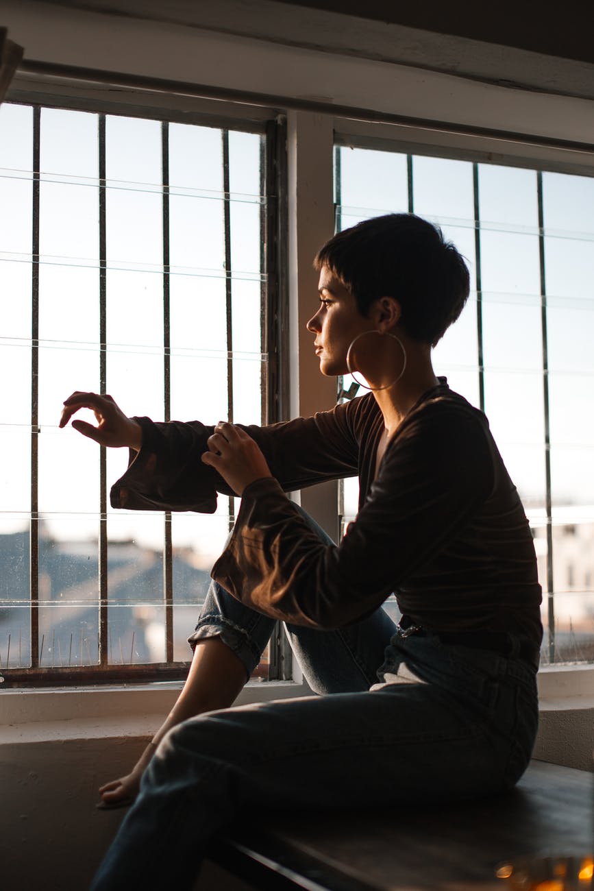 tranquil woman sitting in solitude near window