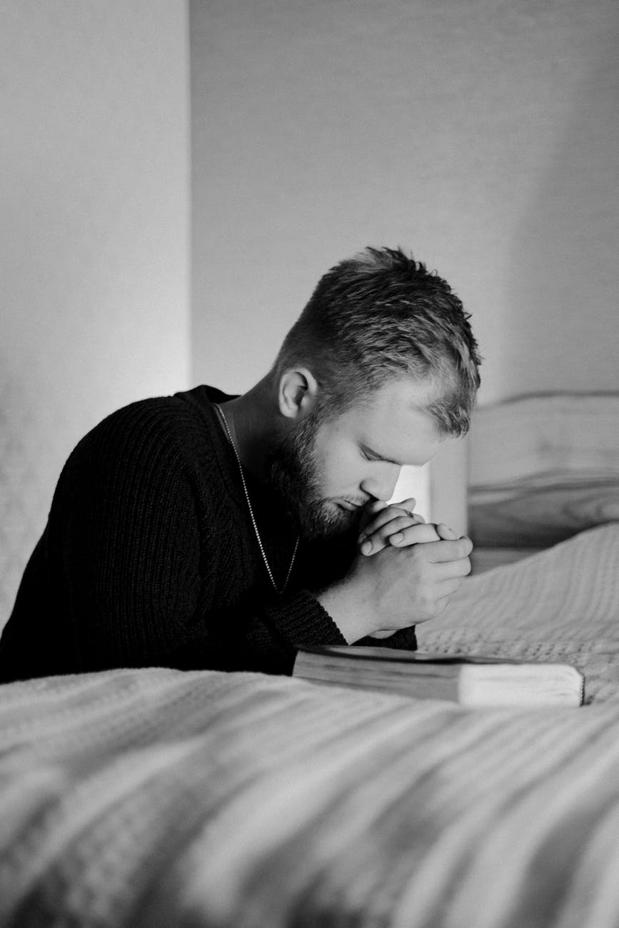 man in black long sleeve shirt sitting on bed