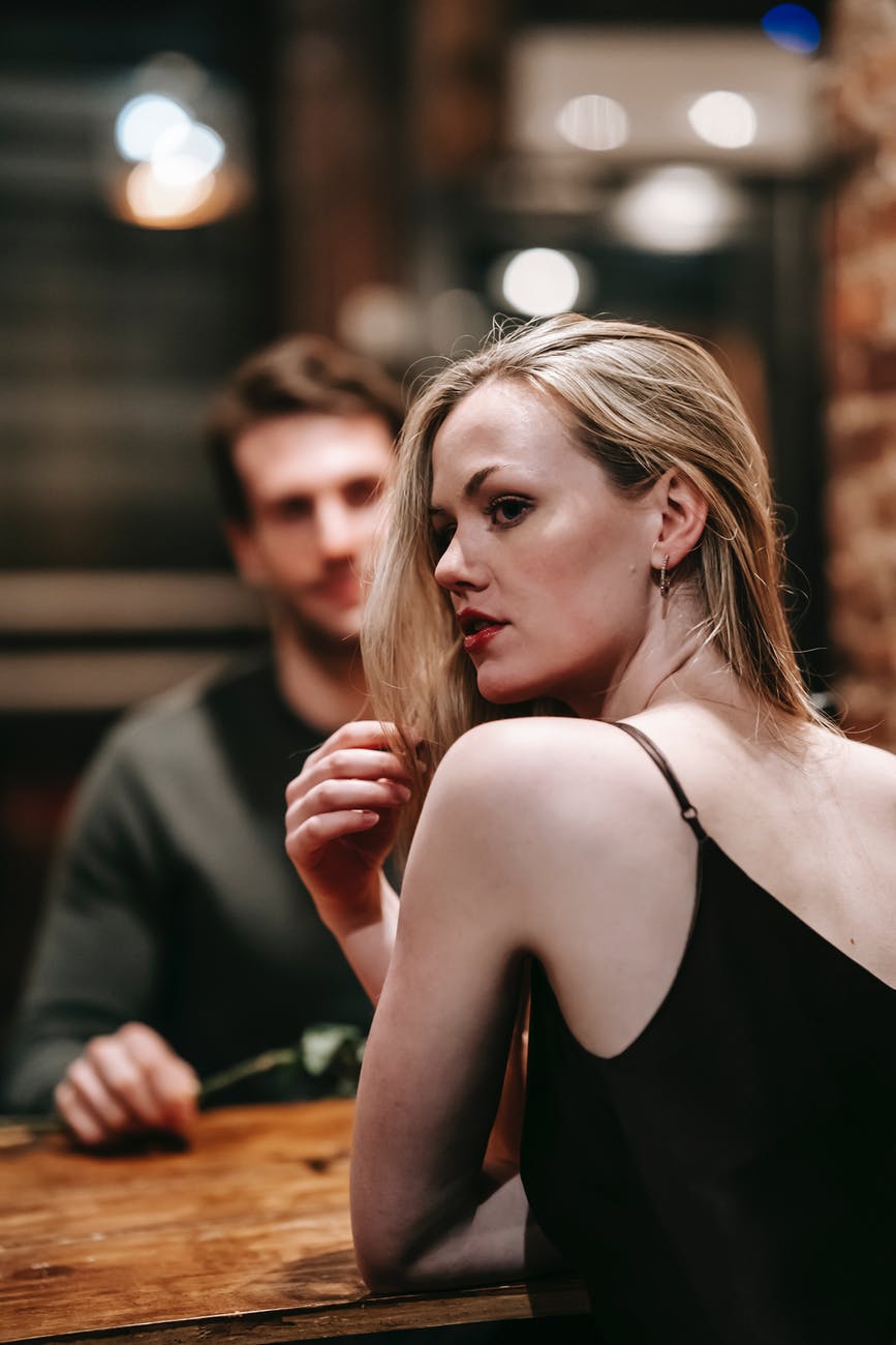 calm woman at table with anonymous man