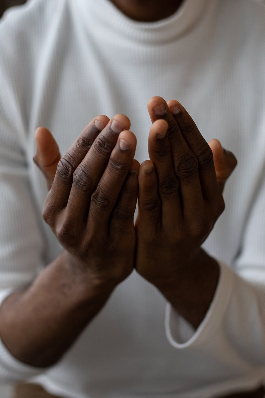 crop black man showing pray gesture