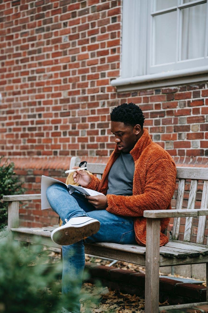 thoughtful black man writing on paper