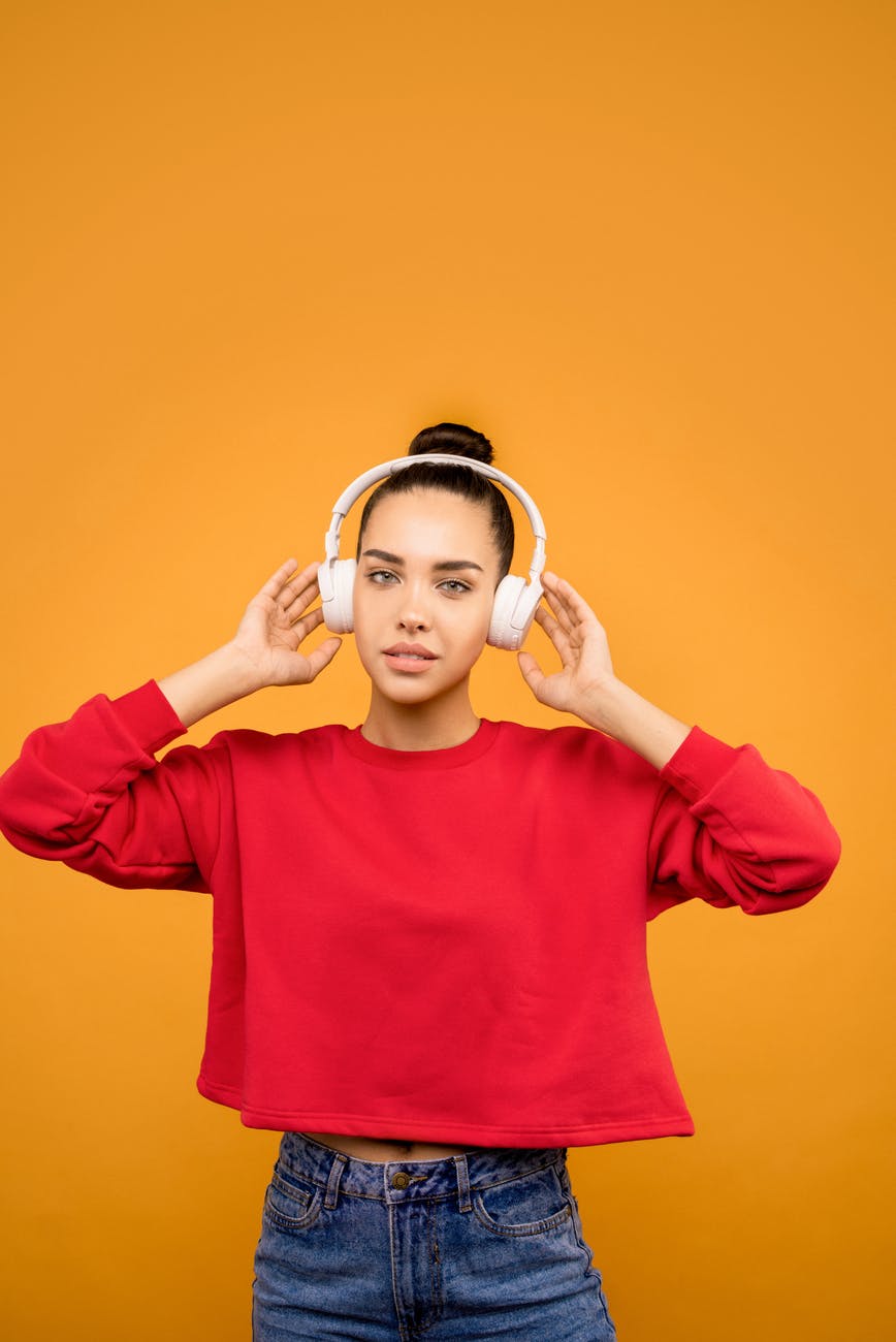 woman in red trendy top listening to music