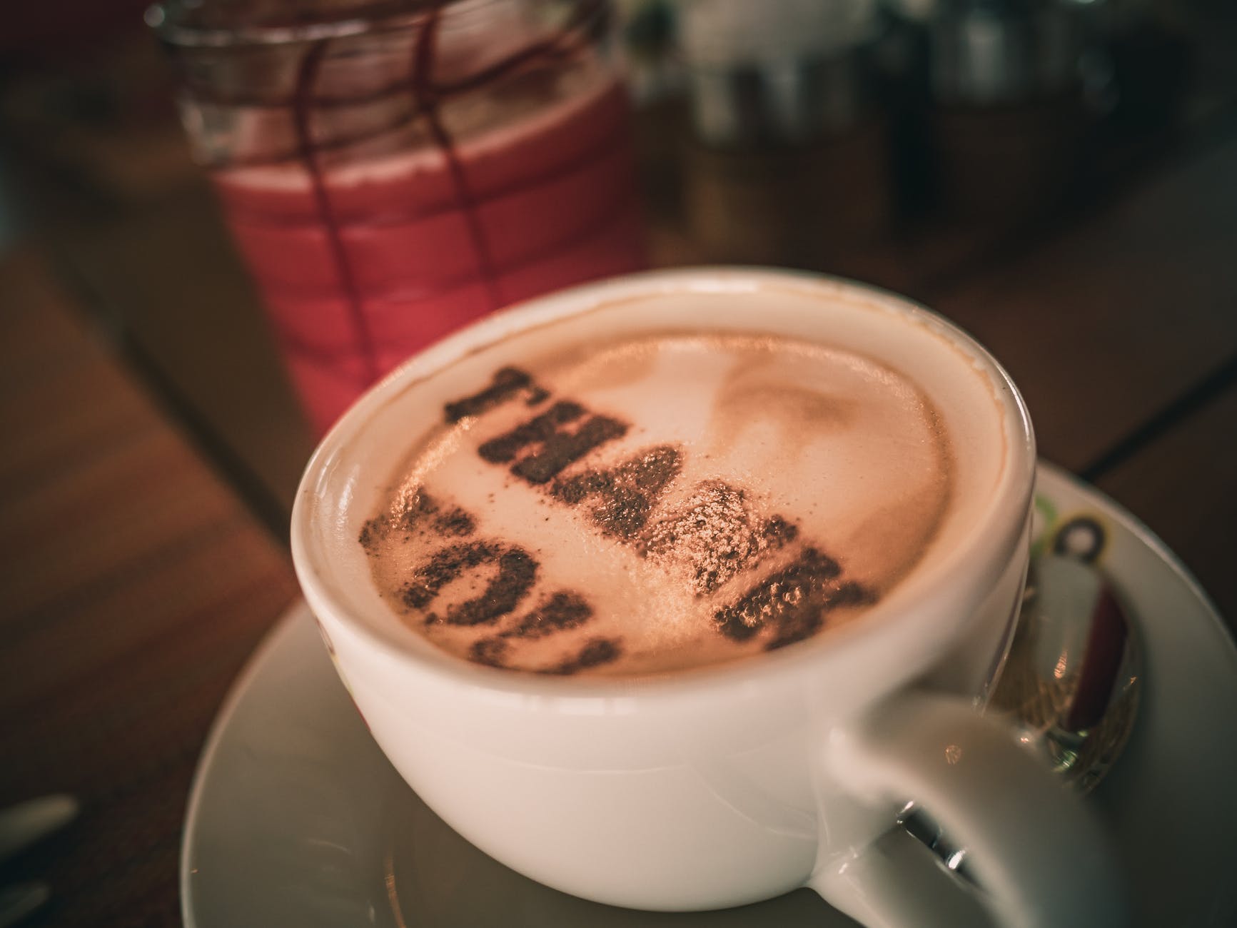 cup of aromatic cappuccino with thank you words on foam