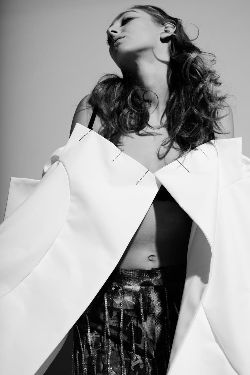 stylish woman lowering creative white jacket in studio