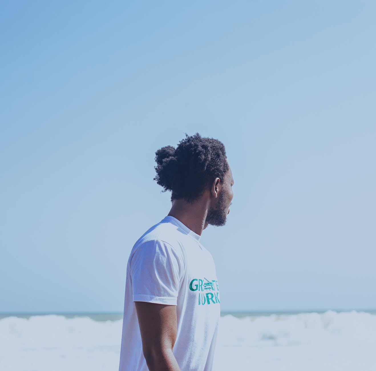 black man admiring foamy ocean in stormy weather