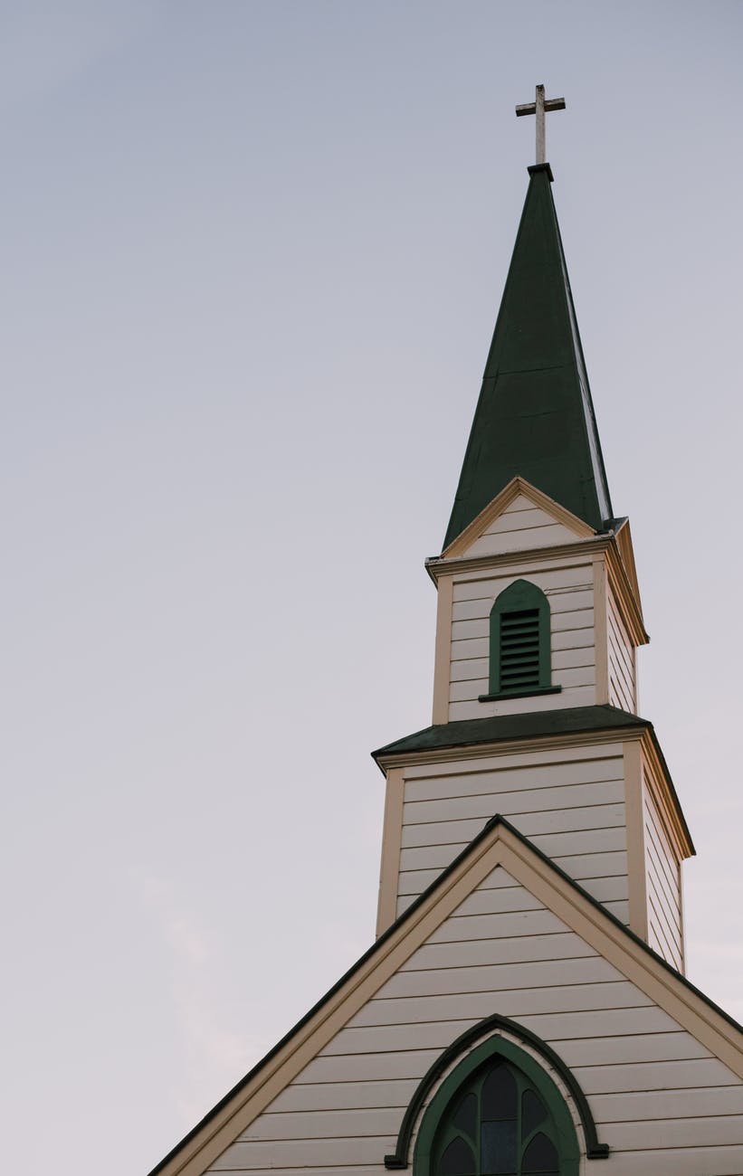 architectural photography of white and green church bell tower under clear sky