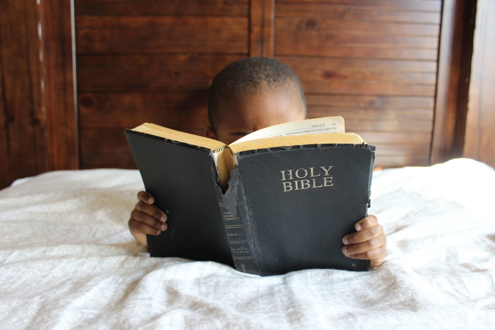 photo of child reading holy bible