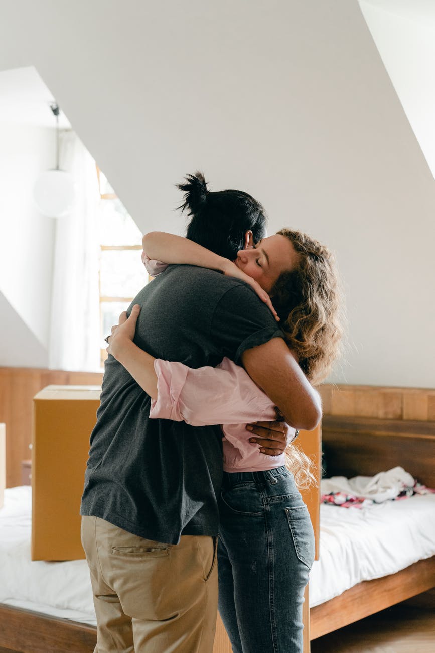 happy couple hugging in new apartment during relocation