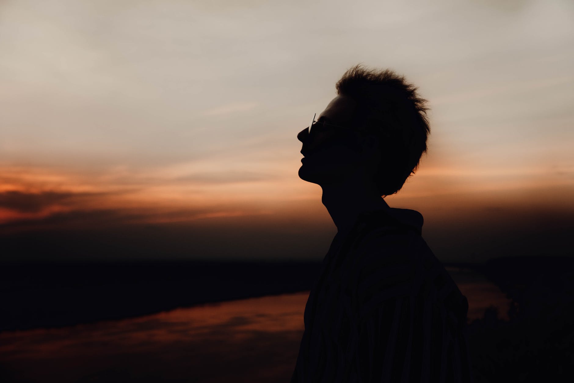 silhouette of man enjoying nature at dusk